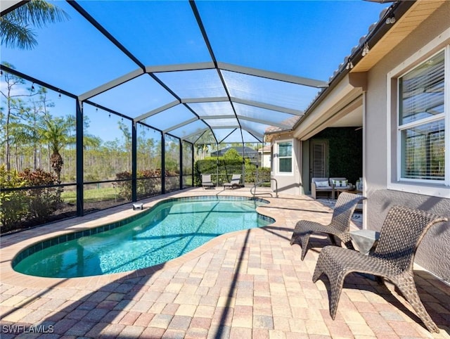 view of pool with glass enclosure, an outdoor living space, and a patio