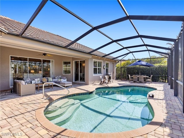 view of swimming pool featuring an outdoor hangout area, ceiling fan, glass enclosure, and a patio