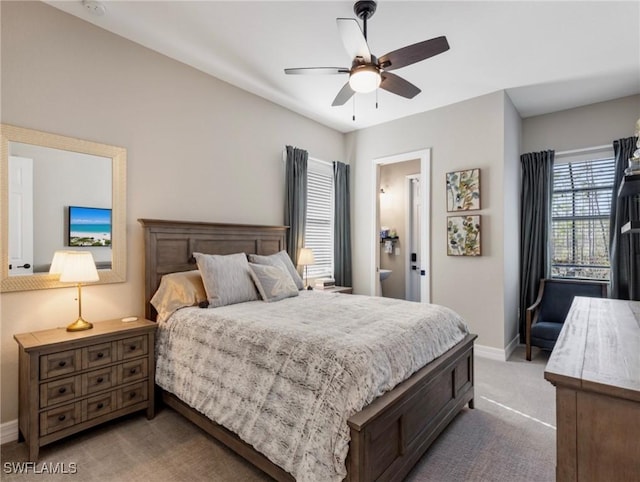 bedroom featuring ceiling fan, light carpet, and connected bathroom