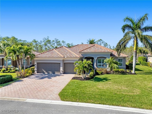 mediterranean / spanish house featuring a front yard and a garage