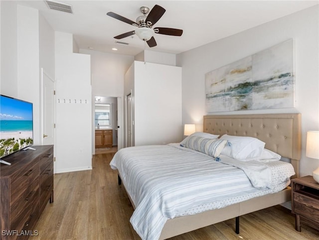 bedroom featuring hardwood / wood-style floors, ensuite bath, and ceiling fan