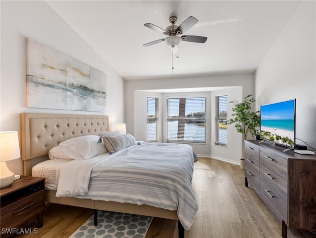 bedroom featuring lofted ceiling, ceiling fan, and light wood-type flooring