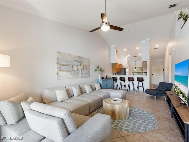 tiled living room with crown molding, high vaulted ceiling, and ceiling fan