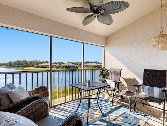 sunroom / solarium with a water view, ceiling fan, and lofted ceiling