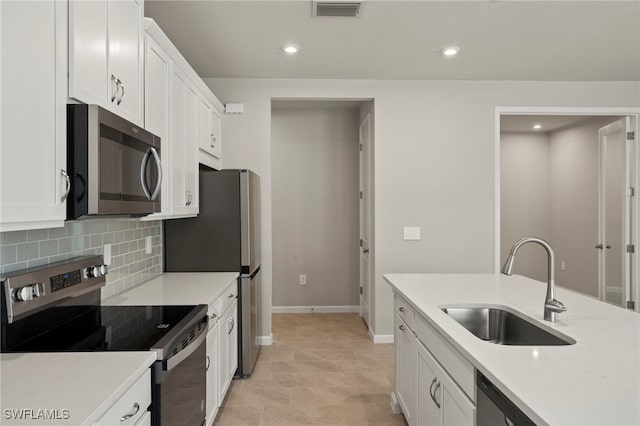 kitchen featuring sink, backsplash, stainless steel appliances, white cabinets, and light tile patterned flooring