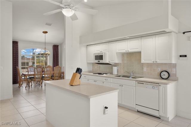 kitchen featuring white appliances, white cabinets, decorative light fixtures, and sink