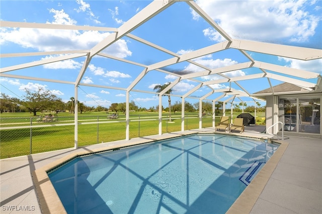 view of swimming pool featuring a lanai, a yard, and a patio area