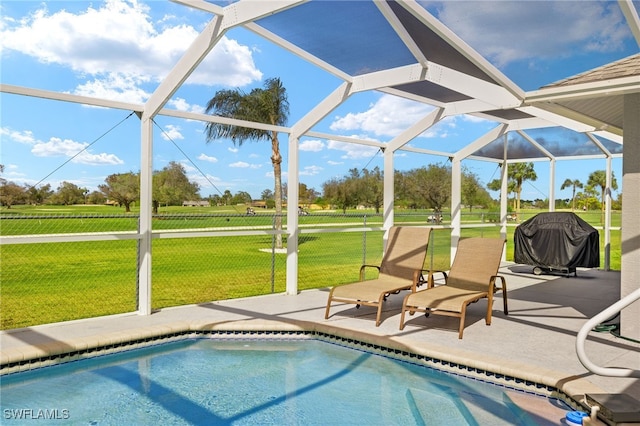 view of pool with a lanai, a patio, a lawn, and a grill