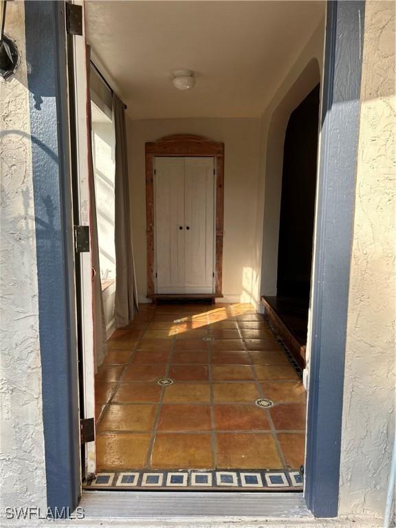 hall with dark tile patterned flooring