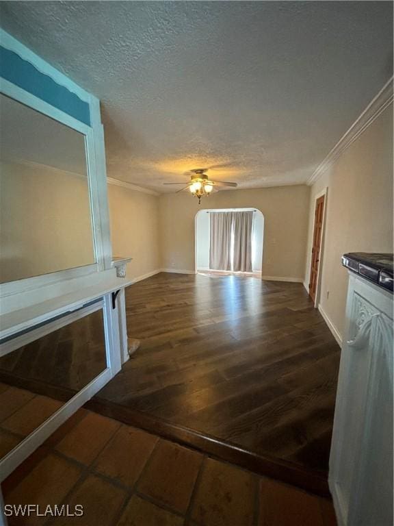 unfurnished living room with a textured ceiling, ceiling fan, crown molding, and dark hardwood / wood-style floors