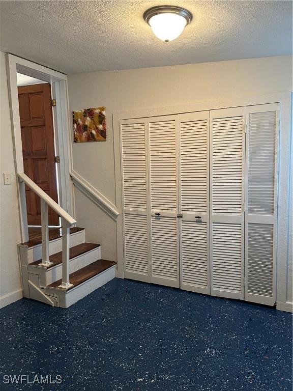 stairway with a textured ceiling