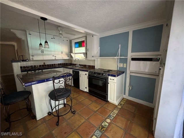 kitchen with black appliances, hanging light fixtures, a textured ceiling, white cabinetry, and sink