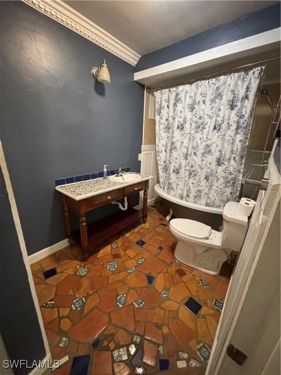 bathroom featuring crown molding and toilet