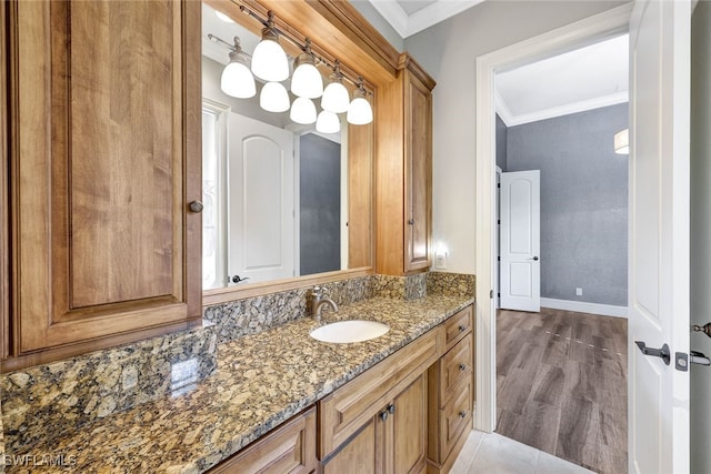 bathroom featuring ornamental molding, wood-type flooring, and vanity