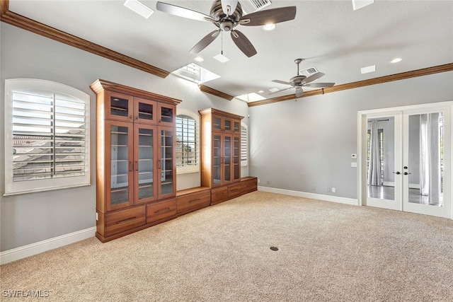 unfurnished living room featuring french doors, light colored carpet, crown molding, and ceiling fan