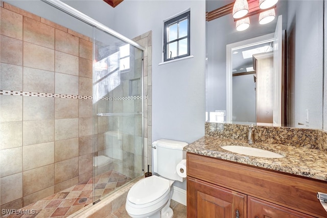 bathroom with walk in shower, vanity, and toilet