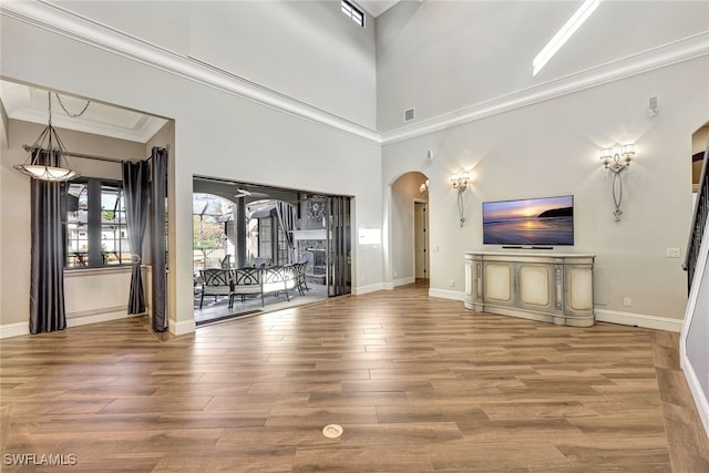 unfurnished living room with crown molding and wood-type flooring