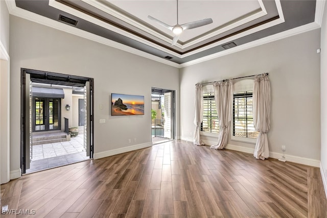 unfurnished room featuring a wealth of natural light, dark hardwood / wood-style flooring, and a tray ceiling