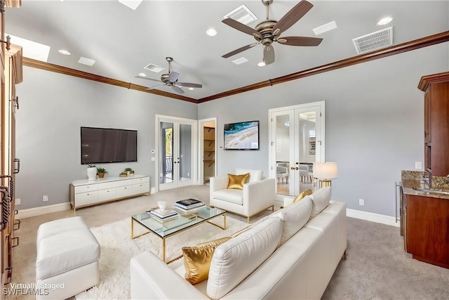 carpeted living room featuring ornamental molding, ceiling fan, and french doors