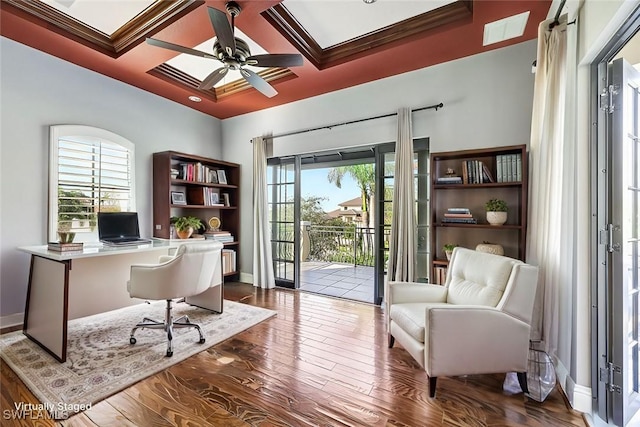 home office featuring hardwood / wood-style floors, beamed ceiling, ornamental molding, coffered ceiling, and ceiling fan