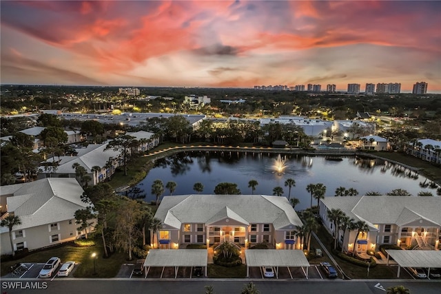 aerial view at dusk featuring a water view