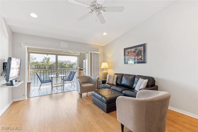 living room with ceiling fan, lofted ceiling, and light hardwood / wood-style flooring