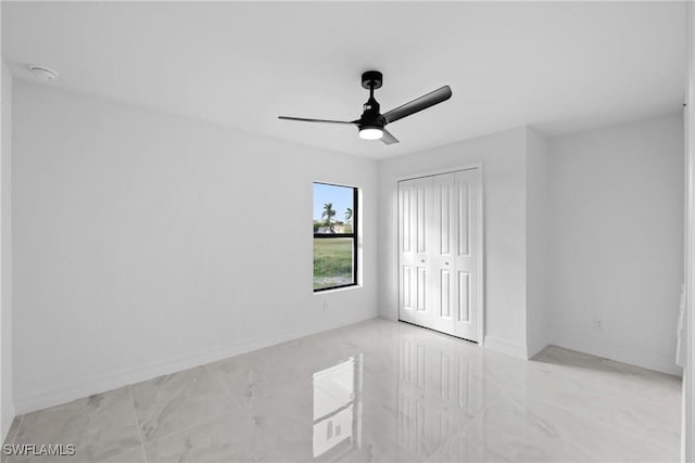 unfurnished bedroom featuring ceiling fan and a closet