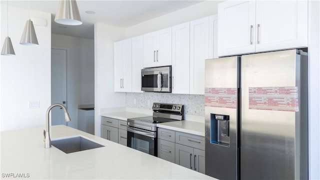 kitchen with stainless steel appliances, white cabinetry, and sink