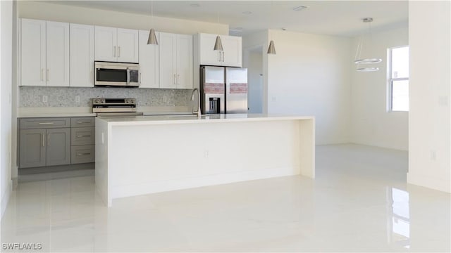 kitchen with gray cabinets, appliances with stainless steel finishes, pendant lighting, white cabinets, and backsplash