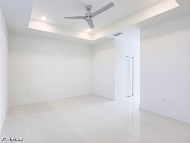 unfurnished room with a raised ceiling and ceiling fan