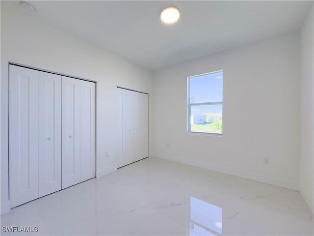 unfurnished bedroom featuring multiple closets