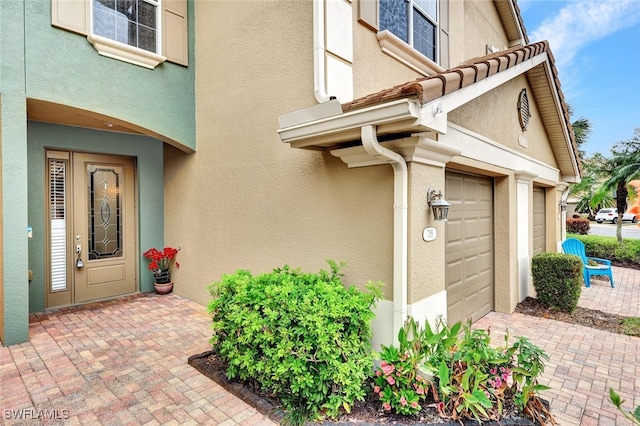 view of exterior entry with a garage