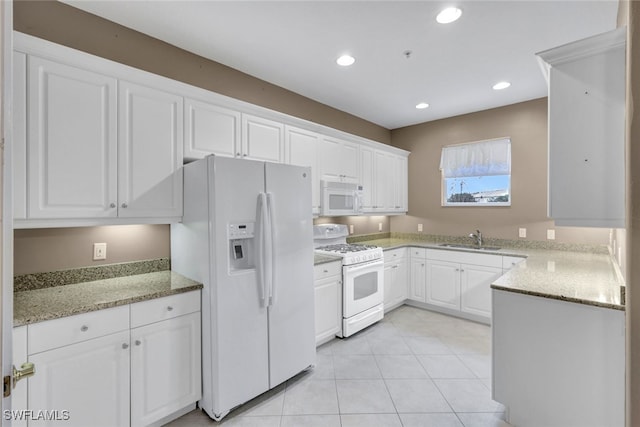 kitchen with white appliances, sink, light stone counters, and white cabinetry