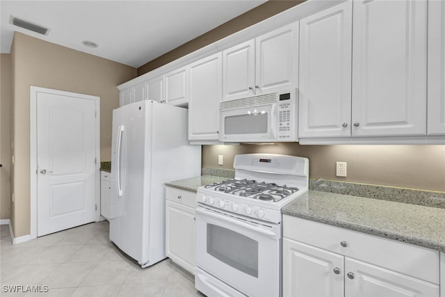 kitchen featuring white appliances, light tile patterned flooring, white cabinets, and light stone counters