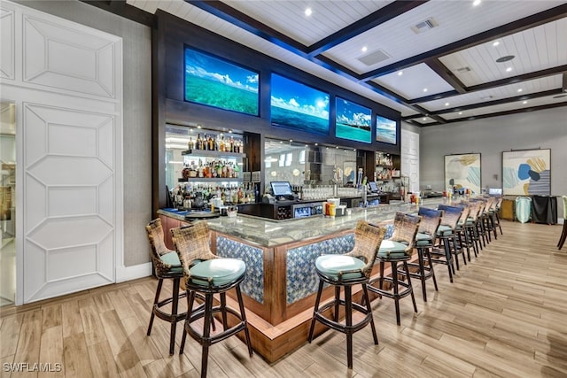 bar featuring light wood-type flooring, beam ceiling, and coffered ceiling