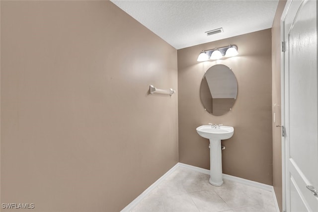 bathroom featuring a textured ceiling and tile patterned floors