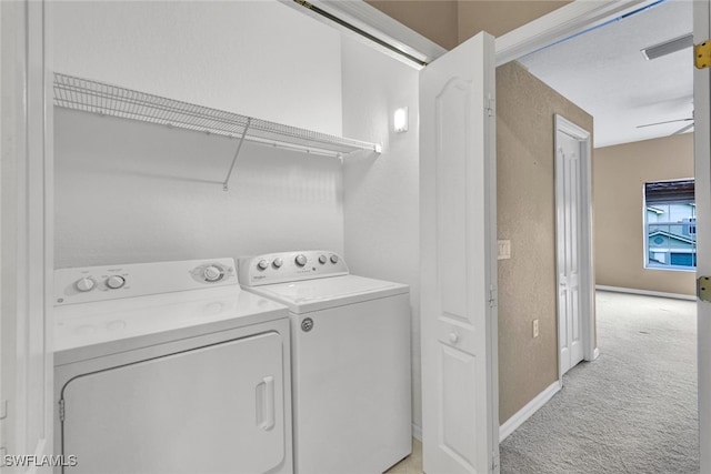 clothes washing area with light colored carpet and washer and clothes dryer