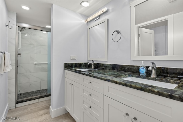 bathroom featuring a shower with shower door, wood-type flooring, and vanity