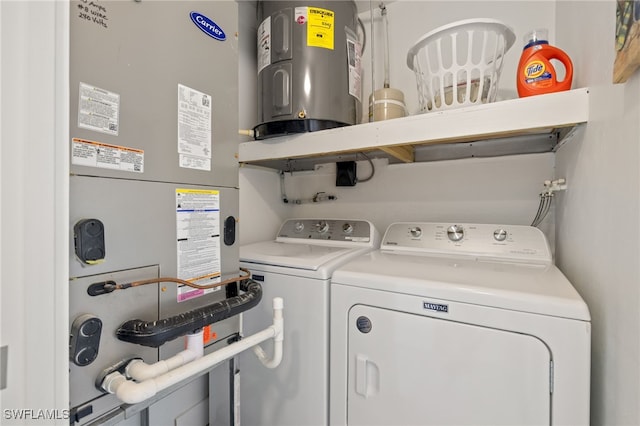 laundry area with washer and dryer, electric water heater, and heating unit