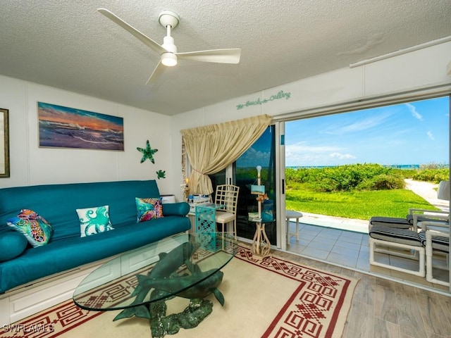 living room featuring hardwood / wood-style flooring, a textured ceiling, and ceiling fan