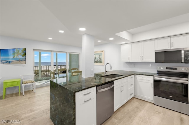 kitchen featuring sink, white cabinetry, stainless steel appliances, and dark stone countertops