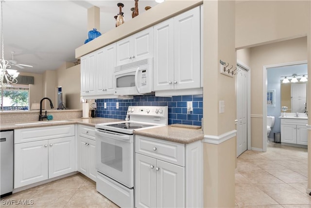 kitchen featuring light tile patterned flooring, white cabinetry, sink, and white appliances