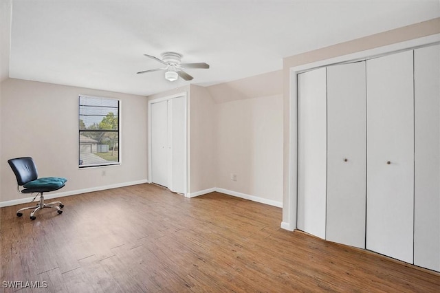 interior space featuring lofted ceiling, wood finished floors, baseboards, and ceiling fan