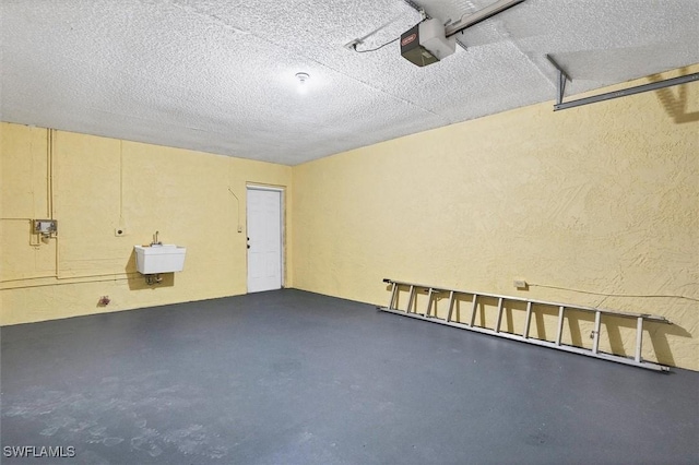 interior space with a sink, a garage door opener, and a textured wall