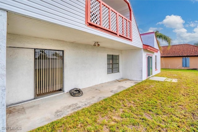 back of property featuring stucco siding and a yard