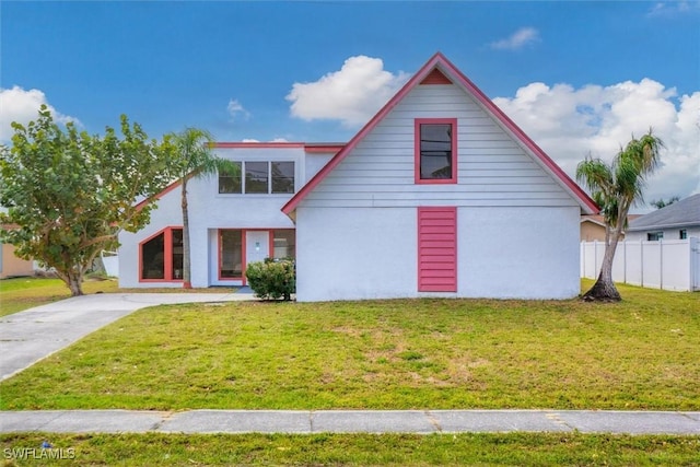 view of front of property featuring stucco siding, a front lawn, and fence