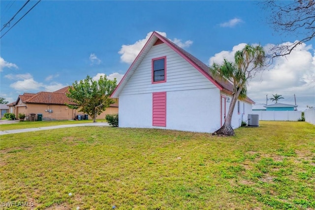 view of property exterior featuring cooling unit, a lawn, stucco siding, and fence