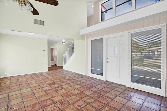 entryway with visible vents, plenty of natural light, stairs, and a high ceiling