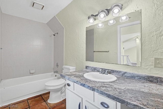 full bath with tile patterned floors, toilet, shower / bathtub combination, vanity, and a textured wall