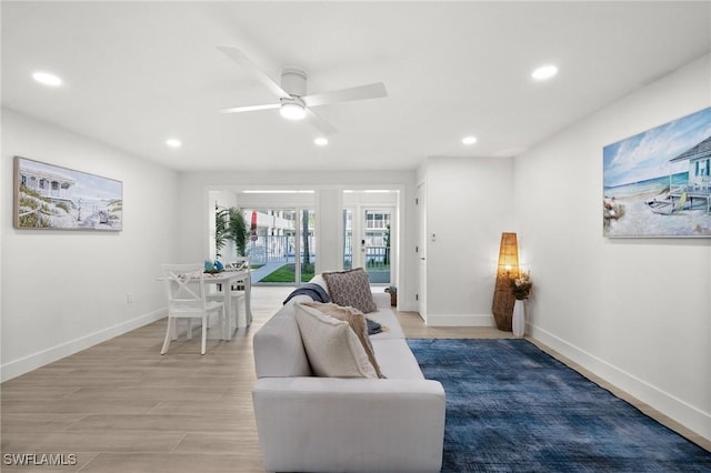 living room featuring ceiling fan and light hardwood / wood-style floors